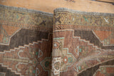 Rolled edge of vintage Oushak rug, showing its intact side selvage and distressed pile.