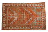 Vintage distressed Oushak rug with prayer mehrab design in terracotta, green, and pale blue.