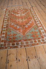 Distressed tangerine and ocean green vintage Oushak rug corner with ivory border and fringe.