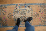 Distressed Oushak runner's abrash field, with ornate beige, blue, and pink patterns.