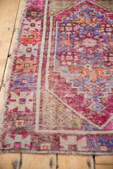Distressed vintage Oushak rug texture with worn pile, intact selvage, pink, purple, orange geometric motifs.