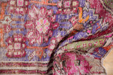 Vintage distressed Oushak rug texture, showing knot wear, foundation, and vivid pink, purple, green.