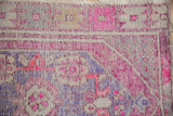 Vintage distressed Oushak rug with worn texture, blush pink, pale aubergine, and visible knot heads.
