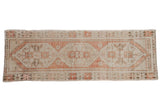 Distressed Oushak runner featuring geometric triple medallions, floral motifs in pale rust, ivory.