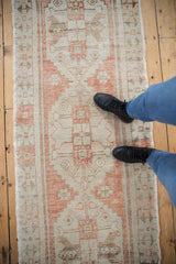 Textural distressed Oushak runner showing geometric patterns in pale rust and ivory underfoot.