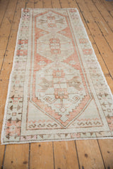 Distressed vintage Oushak runner showing textured pile and geometric pale rust motif.