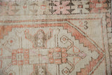 Distressed Oushak runner pile with pale rust, ivory, and sandalwood stepped geometric patterns.