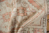 Distressed vintage Oushak runner texture, showing worn pile, ivory, and pale rust knot heads.