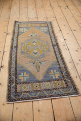 Distressed Oushak runner's geometric motif, revealing even wear and beige, blue, gold tones.