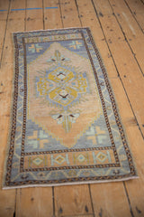 Distressed Oushak rug corner with intact brown selvage, blue border, and beige stepped spandrel.