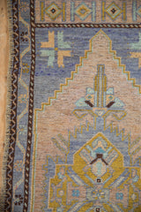 Vintage Oushak runner's geometric stepped corner, even wear, pale blue, gold, and beige tones.