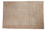 Vintage distressed Oushak carpet with repeating gul motif, time-softened ivory, blush, seafoam tones.