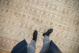 Distressed Oushak rug's soft ivory, pale blush, and seafoam green gul pattern from above.