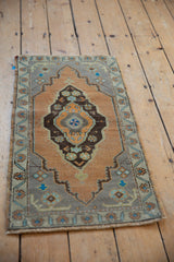 Distressed vintage Oushak rug corner with sandalwood field, slate blue spandrel, and floral details.