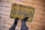 Distressed vintage Kars rug mat, geometric rams horn gul pattern, dusty gold green.