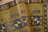 Textured pile of vintage Kars rug with charcoal geometric rams horn and pinwheel motifs.