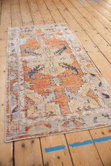 Distressed vintage Oushak runner showing aged terracotta, blue, and ivory primitive motifs.