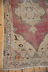 Distressed Oushak runner border with meandering vine, scrolling buds, mauve, ivory tones.