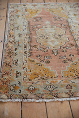 Distressed Oushak rug with dusty sandalwood and saffron palmettes, showing foundation wear.