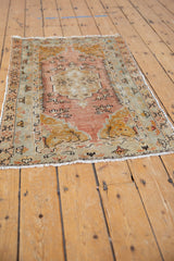 Distressed vintage Oushak rug end with worn saffron, sandalwood, and seafoam patterns, subtle fringe.