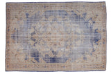 Distressed vintage Oushak carpet, featuring a faded denim blue field and antique ivory floral medallion.