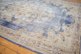 Distressed Oushak rug with faded denim blue field and ornate antique ivory border design.