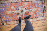 A top-down perspective showing the distressed texture and scale of a vintage Oushak rug.