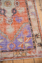 Worn low pile and pinwheel corner spandrel of a vintage distressed Oushak rug runner.