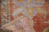 Distressed Oushak rug folded corner showing worn pile, foundation, and 'Made in Turkey' mark.