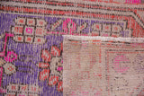 Distressed vintage Oushak rug foundation showing bright pink, purple, and terra cotta threads.