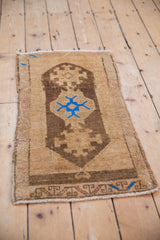 Distressed Oushak rug corner with pale coffee brown geometric pattern and blue detail.