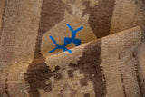 Distressed vintage Oushak rug's short pile, featuring blue geometric and muted tones.