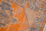 Distressed vintage Oushak rug pile, revealing foundation in tangerine orange and charcoal.