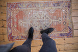 Distressed vintage Turkish Oushak rug showcasing a geometric medallion, faded terra cotta, ivory, and muted purple.