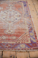 Textured distressed Oushak rug corner, showing worn pile, delicate fringe, and rich patina.