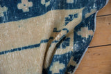 Distressed blue and ivory Oushak rug pile showing mostly even wear and visible foundation.