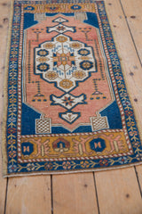 Distressed vintage Oushak rug showing sandalwood field, cobalt blue, and starburst floral detail.