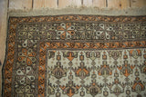 Upper corner of antique Caucasian rug, featuring original macrame, tangerine borders, and serrated floral field.