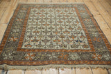 Antique Caucasian rug with tangerine orange border, geometric field, and intact macrame fringe.