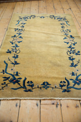 Golden field with cobalt blue Art Deco floral vinery and pale mauve blossoms.