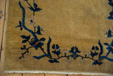 Vintage Art Deco rug corner with gold field, blue floral vinery, selvage, and fringe.