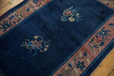 Vintage Chinese Art Deco rug's cobalt field, mauve blossomed border, and visible knot heads.