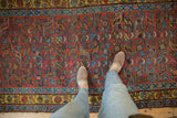 Kurdish Bijar runner: brick red field, spiraled blue floral motifs, saffron yellow border.