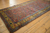 Kurdish Bijar runner featuring a deep saffron yellow border and vibrant spiraled floral patterns.