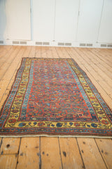 Kurdish Bijar runner with brick red field, spiraled florals, and vibrant saffron yellow border.