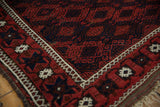 Corner view of an antique Persian Belouch rug with its lattice of floral guls.