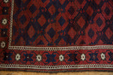 Intact plain weave end and geometric border of an antique hand-knotted Persian Belouch rug.
