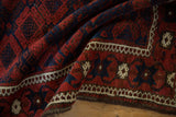 Richly textured pile of an antique Belouch rug with red and cobalt blue paneled guls.