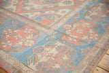 Distressed Soumac flatweave rug detail with peach, blue, ivory, and grey geometric patterns.
