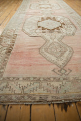 Distressed Oushak runner with abrashed dusty raspberry field and brown geometric motifs.
